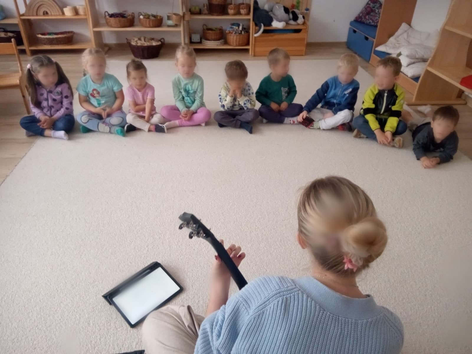 Krąg muzyczny — nauczycielka gra na gitarze
